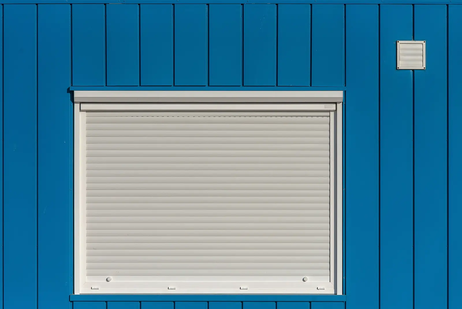 Volet roulant sur une façade bleue